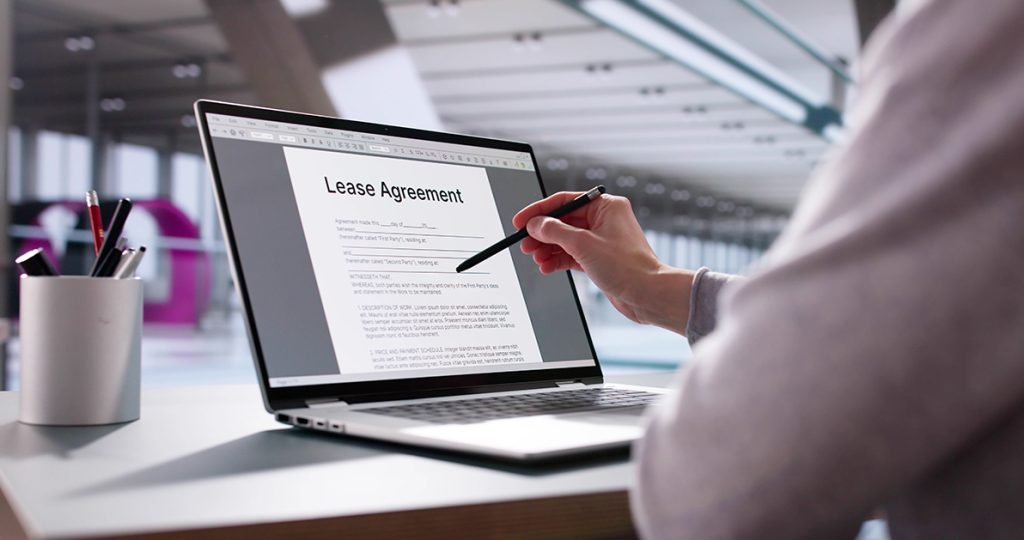Real estate professional reviewing automated rental agreement contract form on laptop